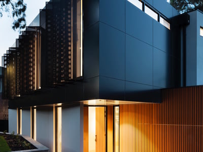 Modern architectural masterpiece featuring sleek lines, contrasting materials, and inviting entrance in a serene setting.