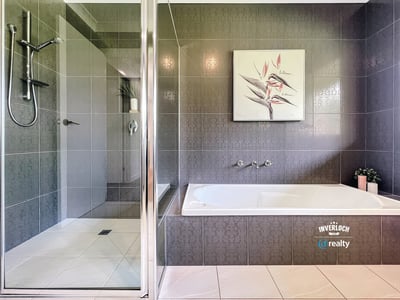 Spacious bathroom featuring a double vanity, modern shower, and relaxing bathtub for ultimate comfort.