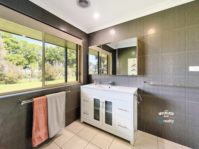 Bright and airy bathroom featuring modern fixtures, ample natural light, and scenic garden views.