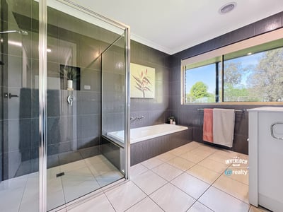 Modern bathroom featuring sleek tiles, a spacious shower, and large windows for natural light.