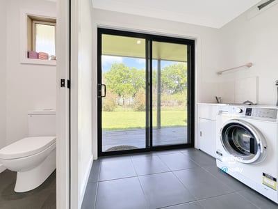 Bright laundry room featuring a washing machine, ample storage, and direct access to the outdoor space.