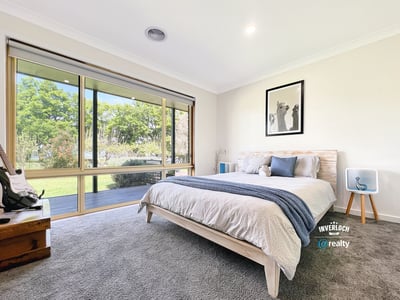 Bright and airy bedroom featuring large windows that invite natural light and offer picturesque garden views.