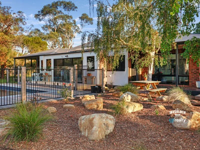 This inviting home features a spacious outdoor area with landscaped gardens and a relaxing poolside retreat.