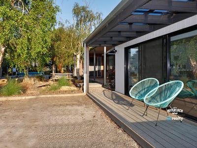Discover this contemporary home featuring inviting outdoor seating and a spacious yard, perfect for entertaining.