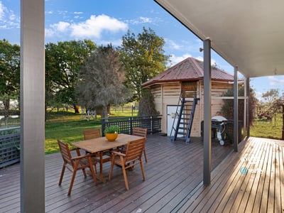 Spacious outdoor deck with direct access to lush greenery, ideal for entertaining and relaxation.