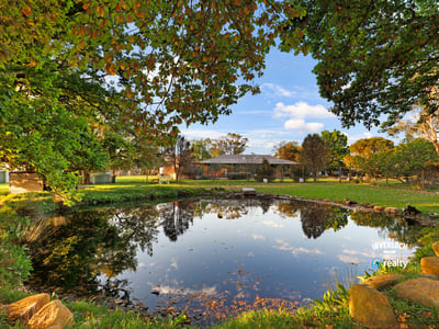 Expansive outdoor space featuring a tranquil pond, surrounded by lush greenery and scenic views.
