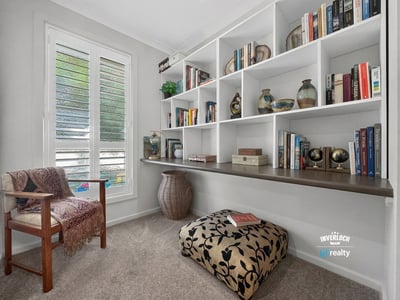 This inviting nook features a custom shelving unit, perfect for book lovers and cozy reading moments.