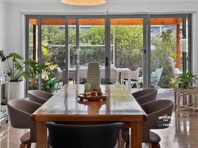 Bright dining area opens to a lush outdoor space, perfect for gatherings and entertaining.