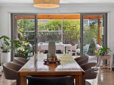 Bright dining area seamlessly connects to a spacious outdoor patio, perfect for entertaining and relaxing.