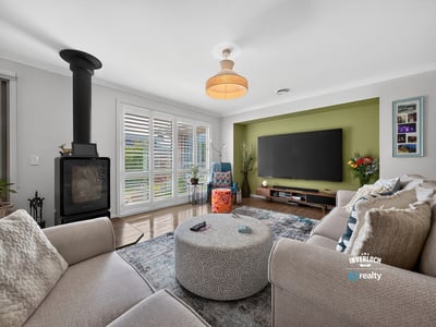 Spacious living area featuring a cozy fireplace, modern entertainment setup, and vibrant accent wall.