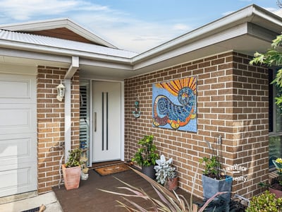 Welcoming entrance features vibrant artwork and lush greenery, offering a warm first impression to visitors.