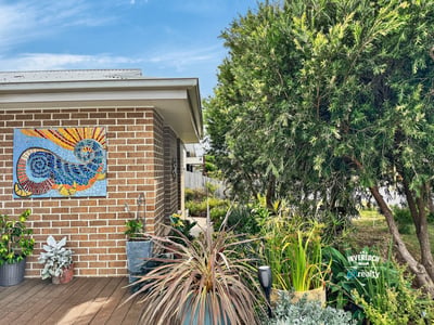 Vibrant garden space with artistic mural, perfect for enjoying outdoor relaxation and entertaining.