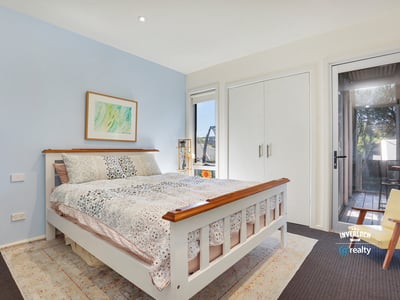Bright bedroom featuring large windows, offering a peaceful atmosphere and easy access to outdoor living space.