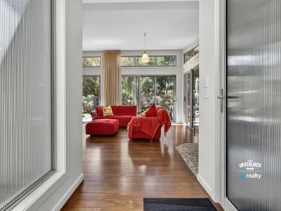 Bright and open living space features large windows and direct access to lush outdoor views.