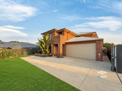 Spacious two-story home with a well-maintained lawn, perfect for family living and outdoor activities.