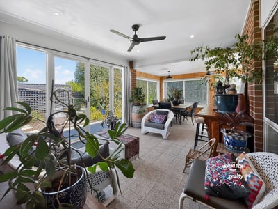 Bright and inviting sunroom with abundant greenery, perfect for relaxation and entertaining year-round.