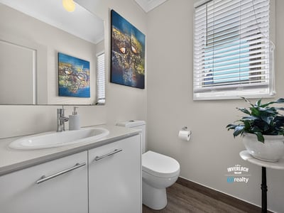 Modern bathroom featuring sleek fixtures, vibrant wall art, and ample natural light for a welcoming atmosphere.