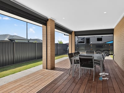 Spacious covered patio perfect for outdoor dining, featuring ample room for entertaining and relaxation.