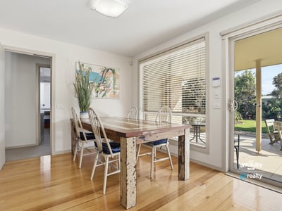 Bright dining area featuring large windows, a spacious table, and easy access to a private outdoor space.