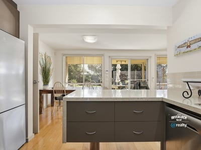 Bright kitchen with modern finishes, open to a sunlit dining area, ideal for entertaining.