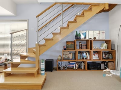 Bright, open space featuring a modern staircase and custom shelving, ideal for showcasing your belongings.