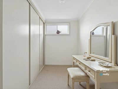 Bright and spacious room featuring ample storage and a versatile vanity area, perfect for personal retreat.