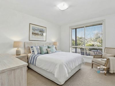 Bright and inviting bedroom featuring large windows, comfortable furnishings, and a relaxing atmosphere.