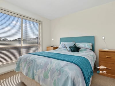 Bright bedroom featuring large windows, contemporary decor, and a cozy atmosphere, perfect for relaxation.