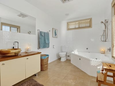 Spacious bathroom featuring a bathtub, modern fixtures, ample light, and thoughtful storage solutions for convenience.