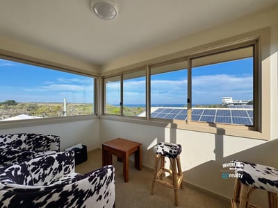Bright sunroom with panoramic ocean views, perfect for relaxation and enjoying natural light.