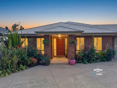 Welcoming home featuring vibrant landscaping and inviting entrance, perfect for enjoying the outdoors.