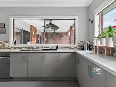 Bright kitchen with modern finishes and a large window overlooking the outdoor living area.
