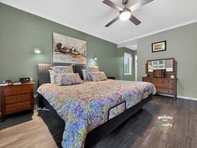 Spacious bedroom featuring a large bed, modern fixtures, and a calming color palette for relaxation.