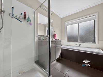 Bright and functional bathroom featuring a glass-enclosed shower and relaxing soaking tub for ultimate convenience.