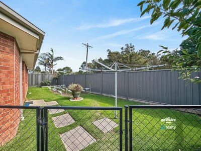 Spacious outdoor area with a fenced yard, perfect for relaxing or gardening on sunny days.