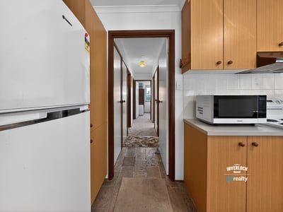 Spacious kitchen leads to ample hallway, offering convenient access to multiple rooms in this inviting home.