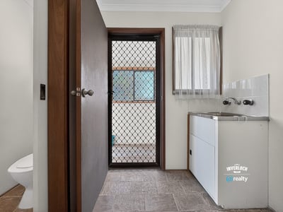 Spacious laundry area with practical features and bright natural light from nearby window.