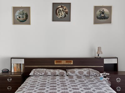 Cozy bedroom featuring vintage decor, modern furnishings, and ample natural light, perfect for relaxation.