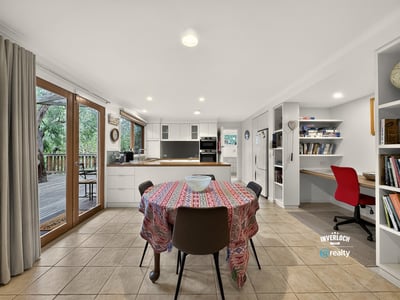 Spacious kitchen with ample natural light, featuring a dining area and convenient workspace for modern living.