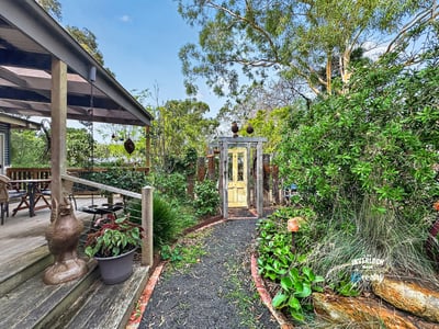 Discover a unique garden pathway leading to a beautifully landscaped outdoor space perfect for relaxation.
