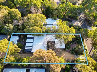 Spacious property surrounded by lush greenery, offering privacy and potential for creative landscaping and development.