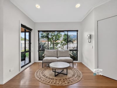 Bright and inviting living space featuring large windows that offer a view of the lush garden.