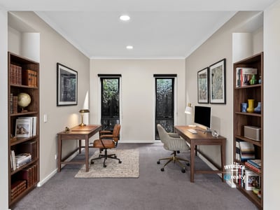 Spacious dual office setup featuring natural light, modern furnishings, and ample shelving for productivity.