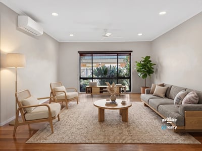 Bright living area features large windows, natural light, and modern furnishings, ideal for relaxed gatherings.