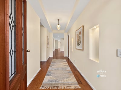 Bright and inviting hallway featuring natural light, modern finishes, and attractive art displays throughout.