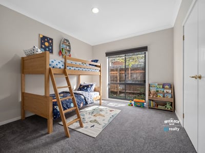 Bright, inviting kids' bedroom featuring a lofted bed and spacious play area with natural light.
