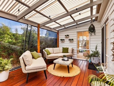 Inviting sunroom featuring comfortable seating, lush greenery, and abundant natural light for relaxed gatherings.