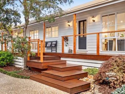 Experience modern living in this inviting home featuring a spacious deck, lush landscaping, and abundant natural light.