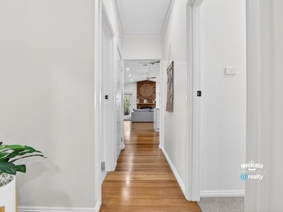 Bright, inviting hallway leading to a spacious living area, showcasing modern design and warmth throughout.
