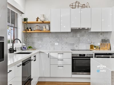 Modern kitchen featuring sleek cabinetry, advanced appliances, and eye-catching tile backsplash for a contemporary culinary experience.